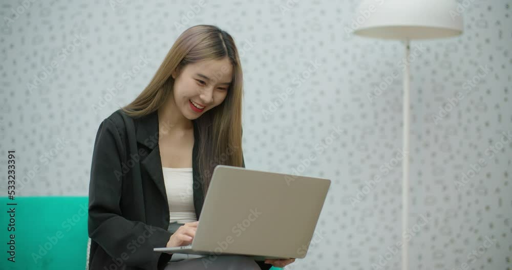 Candid Young beautiful asian business woman using laptop surfing on internet during leisure time. Happy smiling girl looking at computer shopping online, watching video movie at coworking space office Candid Young beautiful asian business woman using laptop surfing on internet during leisure time. Happy smiling girl looking at computer shopping online, watching video movie at coworking space office