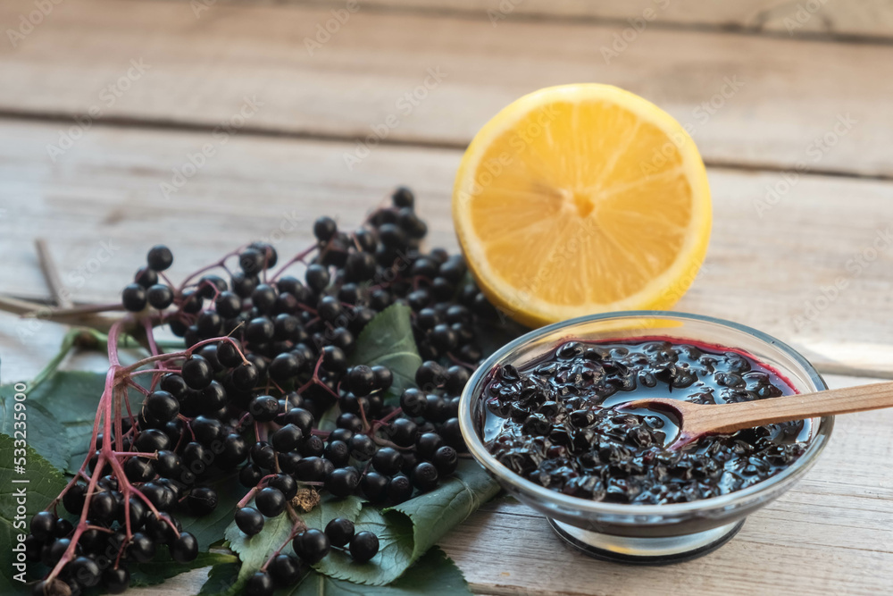 Elderberry jam, fresh berries and leaves and lemon.