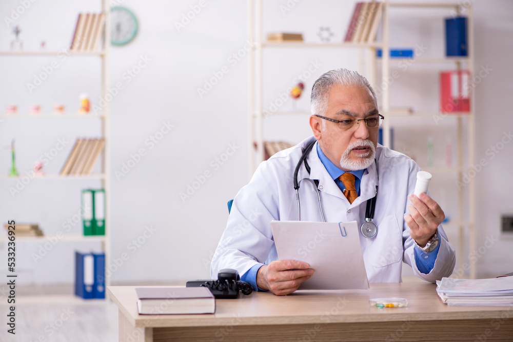 Old male doctor working in the clinic Old male doctor working in the clinic