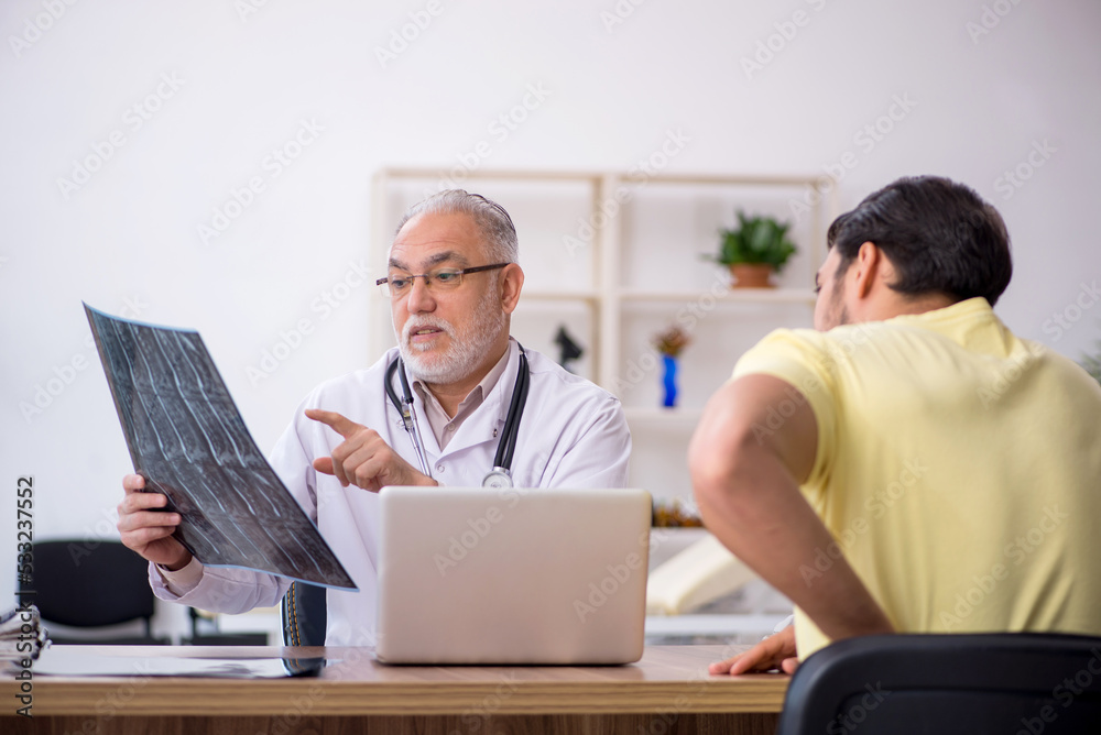 Young male doctor visiting old male doctor radiologist Young male doctor visiting old male doctor radiologist