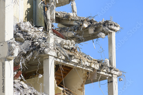 Closeup Reinforced concrete building structure partially demolished as a web structure against a blue sky photo