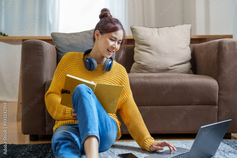 Portrait of a young Asian woman using a computer on the sofa