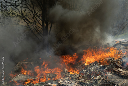 Fire and black smoke. Fire in landfill. Smoke in forest. Illegal landfill. © Олег Копьёв