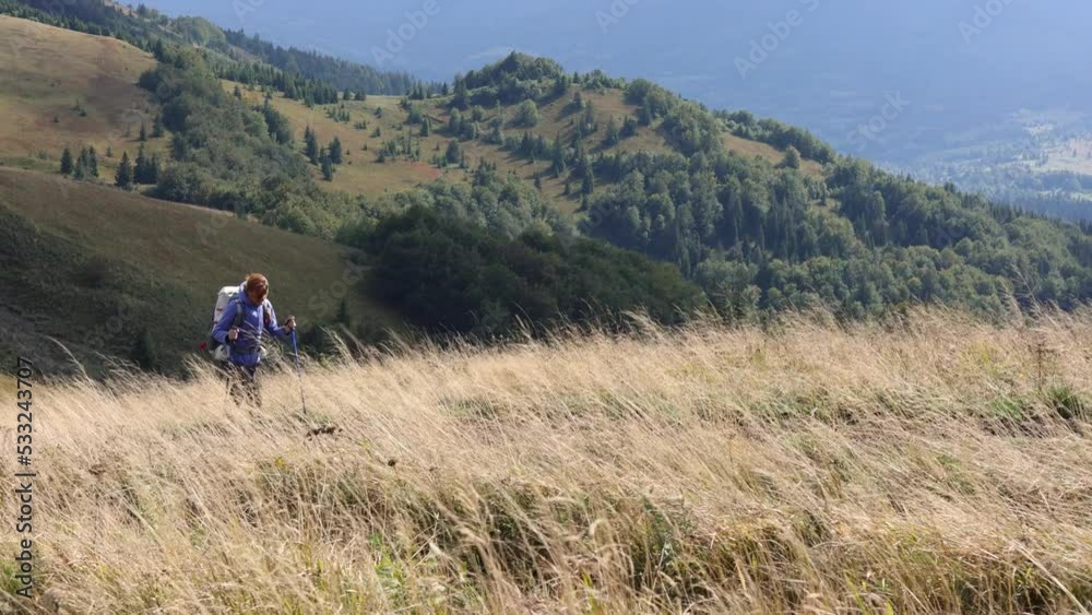 girl hiker walking by the grassy mountain hill girl hiker walking by the grassy mountain hill
