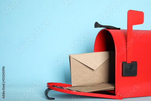 Photography Open red letter box with envelopes on turquoise background, closeup