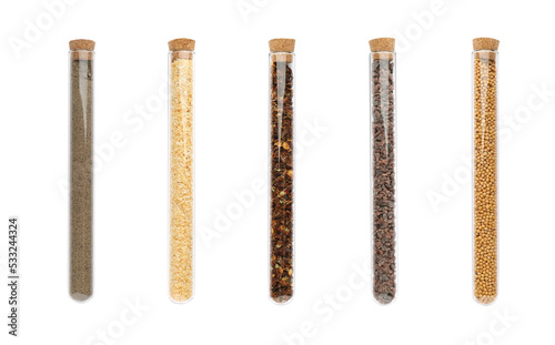 Set of glass tubes with different spices on white background, top view