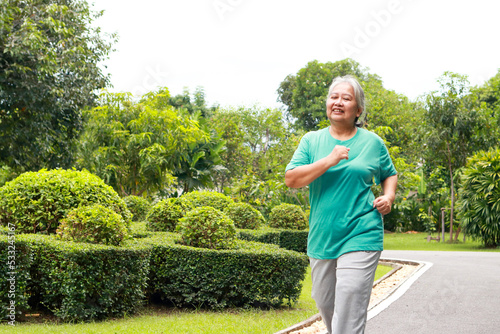 elderly woman Smile and enjoy exercising. Elders jogging in the park. Concept of health care to be healthy in retirement