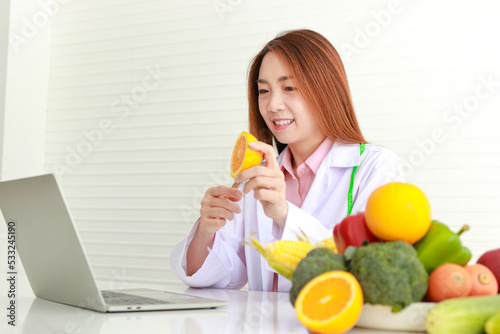 Asian female doctor or nutritionist Consulting the patient about the diet There were various fruits and vegetables lying on the white table. online patient health care concepts, healthy eating.