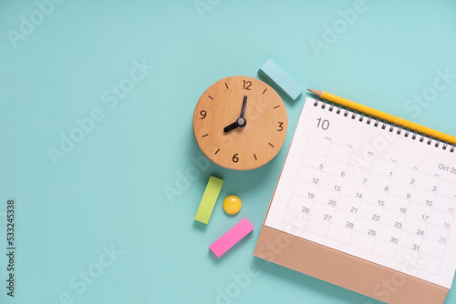 close up of calendar and alarm clock on the green table background, planning for business meeting or travel planning concept