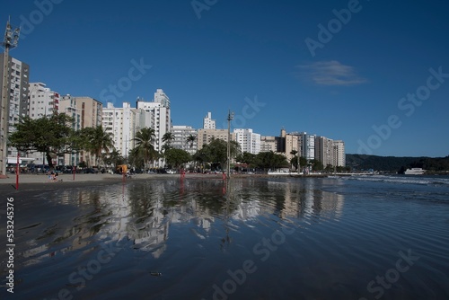Santos  Brazil. Waterfront buildings reflected in the sea water of the beach. Ponta da Praia region.