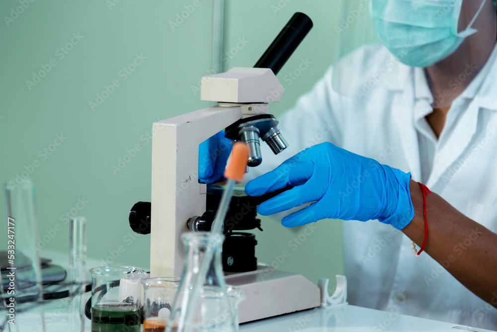 Close up African american Scientist man hands look into Microscope research in science laboratory. Crop biochemistry scientist hands using microscope in laboratory chemistry labs medical researcher Close up African american Scientist man hands look into Microscope research in science laboratory. Crop biochemistry scientist hands using microscope in laboratory chemistry labs medical researcher
