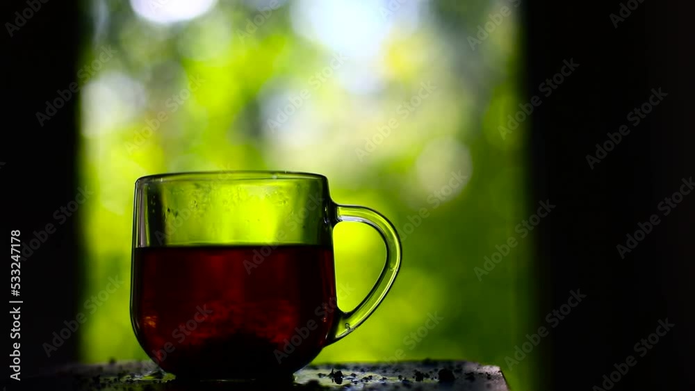 Tea in sunlight from window. Drink in clear glass. Morning tea. Breakfast on summer day. Tea in sunlight from window. Drink in clear glass. Morning tea. Breakfast on summer day.
