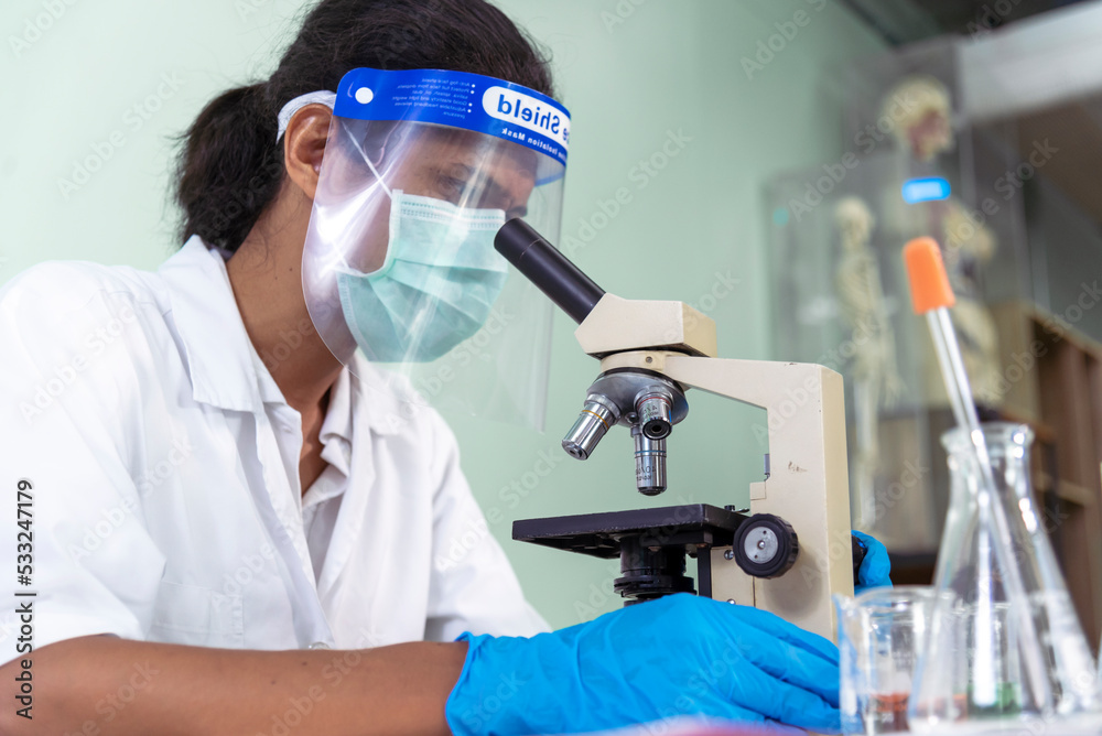 African american Scientist man look into Microscope research in science laboratory. Asian biochemistry scientist using microscope in laboratory chemistry labs. Medical research scientific experiment African american Scientist man look into Microscope research in science laboratory. Asian biochemistry scientist using microscope in laboratory chemistry labs. Medical research scientific experiment