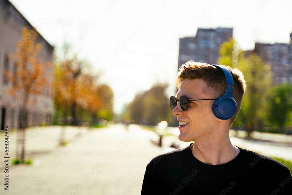 Side view guy with headphones on sunny day Side view guy with headphones on sunny day