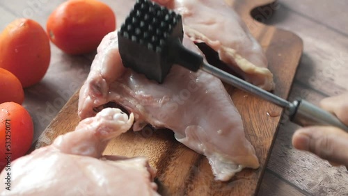 precessing raw chicken breast on a chopping board  photo