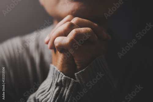 Christ religion and christianity worship or pray concept. Christian catholic woman are praying to god in dark at church. Prayer person hand in black background. Girl believe and faith in jesus christ. photo
