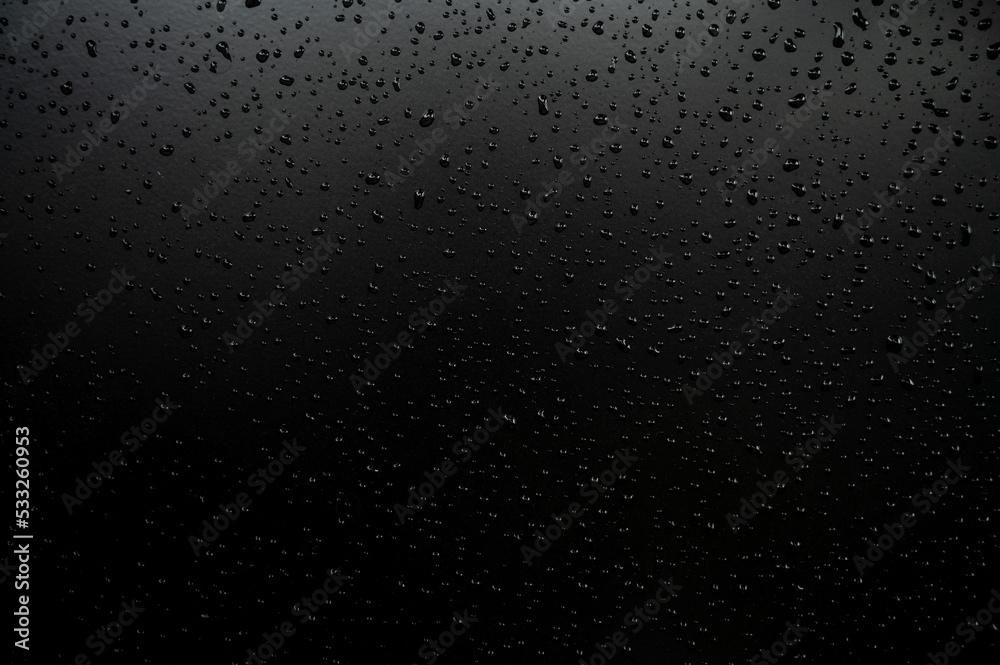 Obraz premium Water droplets on the floor with black background