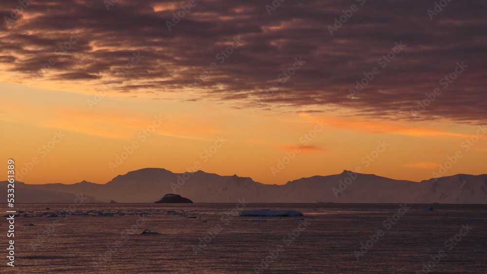 Colorful sunset, with clouds glowing with pink light, at Cierva Cove, Antarctica