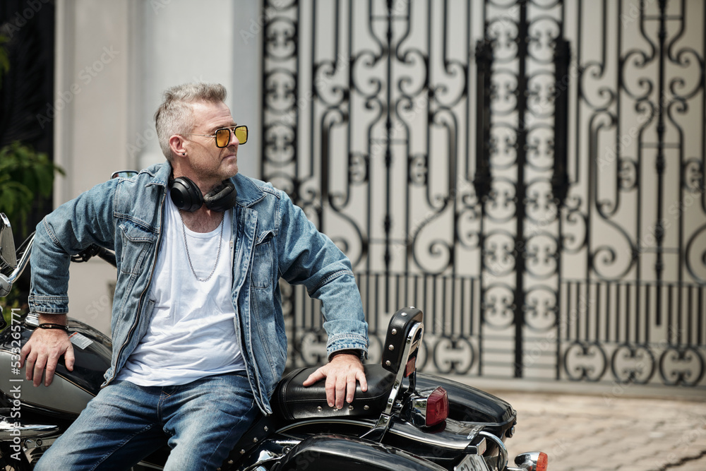 Mature Man Leaning on Motorcycle Mature Man Leaning on Motorcycle