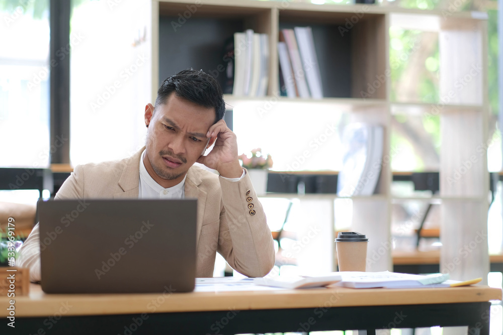 Obraz premium Tired frustrated young asian businessman feeling stressed holding head with hands, business problem failure concept