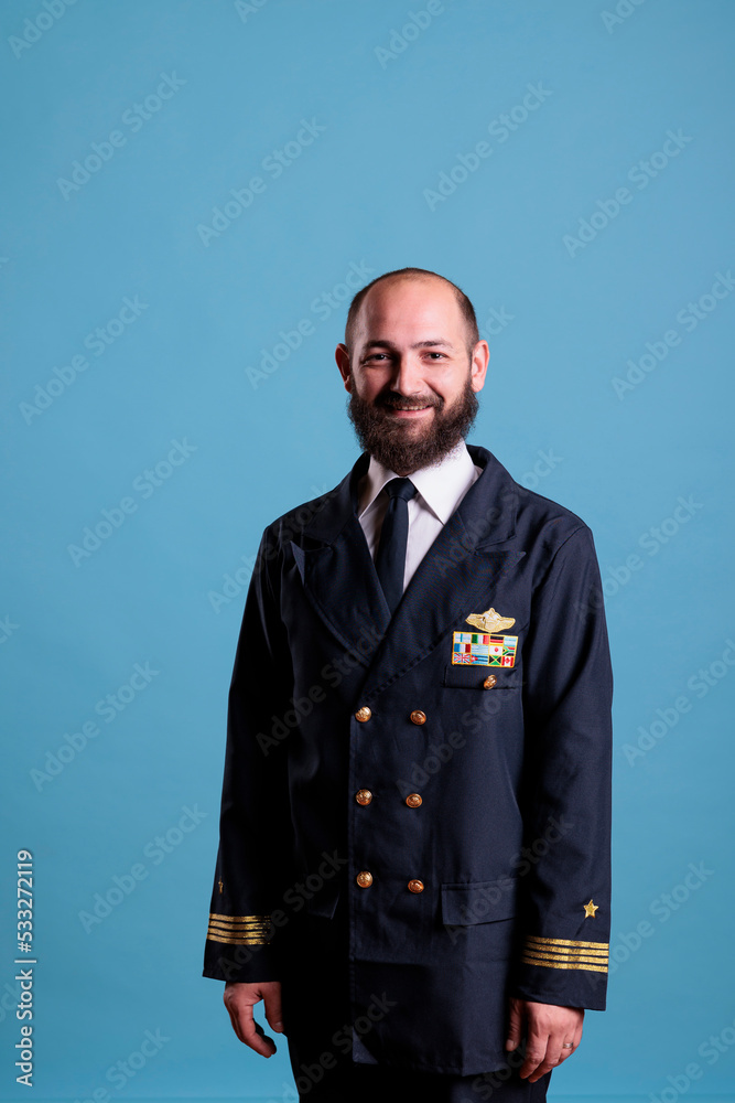 Airplane captain wearing uniform portrait, confident plane captain standing, looking at camera, studio medium shot. Serious handsome pilot with badge on professional costume Airplane captain wearing uniform portrait, confident plane captain standing, looking at camera, studio medium shot. Serious handsome pilot with badge on professional costume