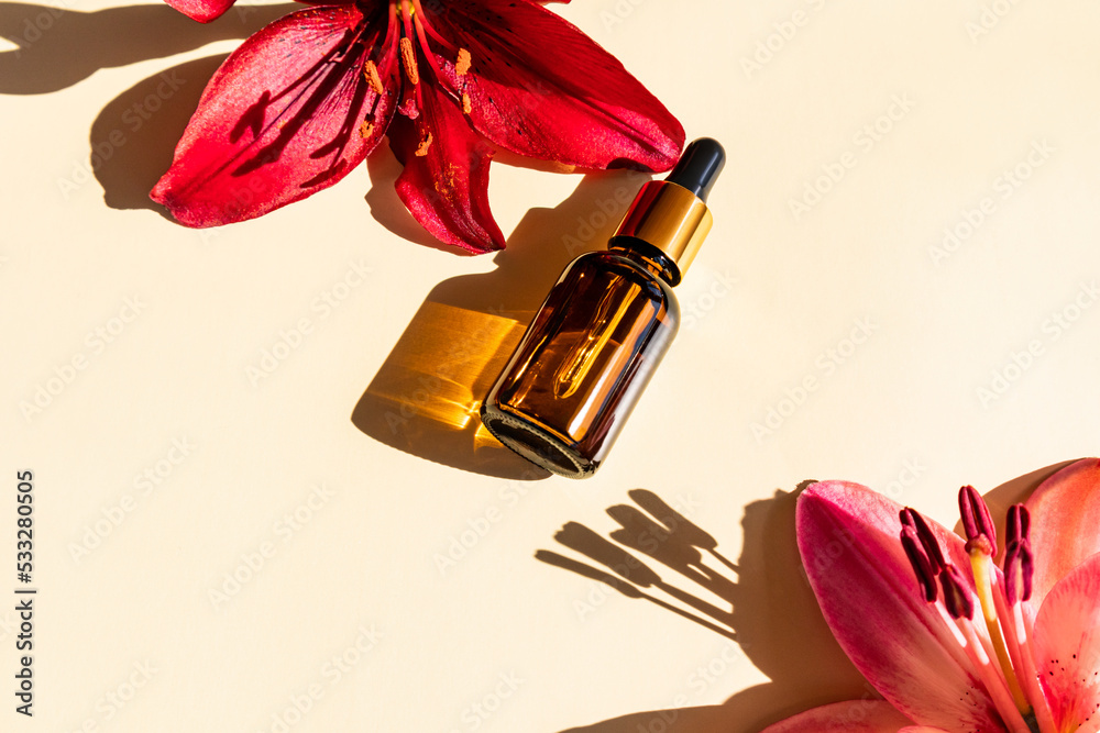 serum for the face in a glass bottle dropper on a beige background with lilies. hyaluronic acid oil, serum with collagen and peptides. serum for the face in a glass bottle dropper on a beige background with lilies. hyaluronic acid oil, serum with collagen and peptides.