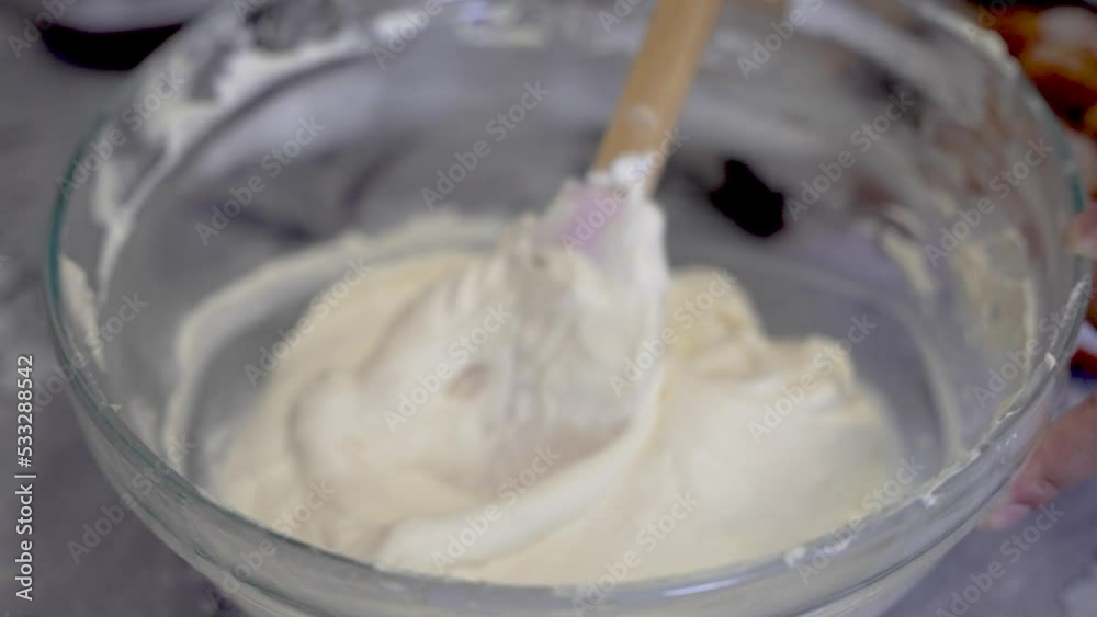 Spatula Stirring Cake Batter Or Cream In Glass Bowl. Close Up, Slow Motion. Foreground Bowl Focus Spatula Stirring Cake Batter Or Cream In Glass Bowl. Close Up, Slow Motion. Foreground Bowl Focus