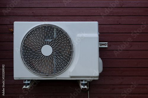 Obraz na płótnie a white heat pump unit mounted on a red wood panel w salonie