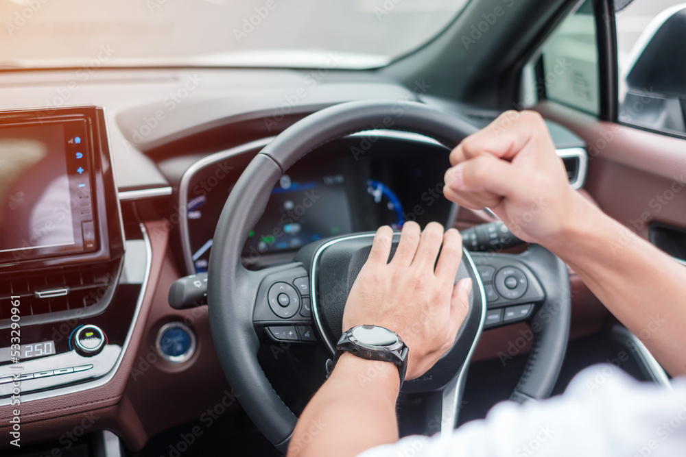 man driver honking a car during driving on traffic road, hand controlling steering wheel in vehicle. Journey, trip and safety Transportation concepts