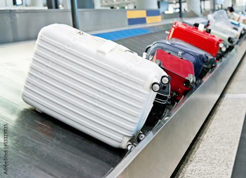 Group of suitcases on conveyor belt of airport photo