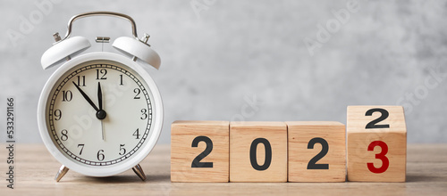 Happy New Year with vintage alarm clock and flipping 2022 change to 2023 block. Christmas, New Start, Resolution, countdown, Goals, Plan, Action and Motivation Concept