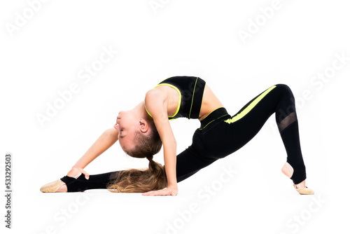 Flexible little girl gymnast in black sports gymnastic suit does acrobatic exercises isolated on a white background with space for text or logo. Sport, workout, fitness, yoga, active lifestyle concept