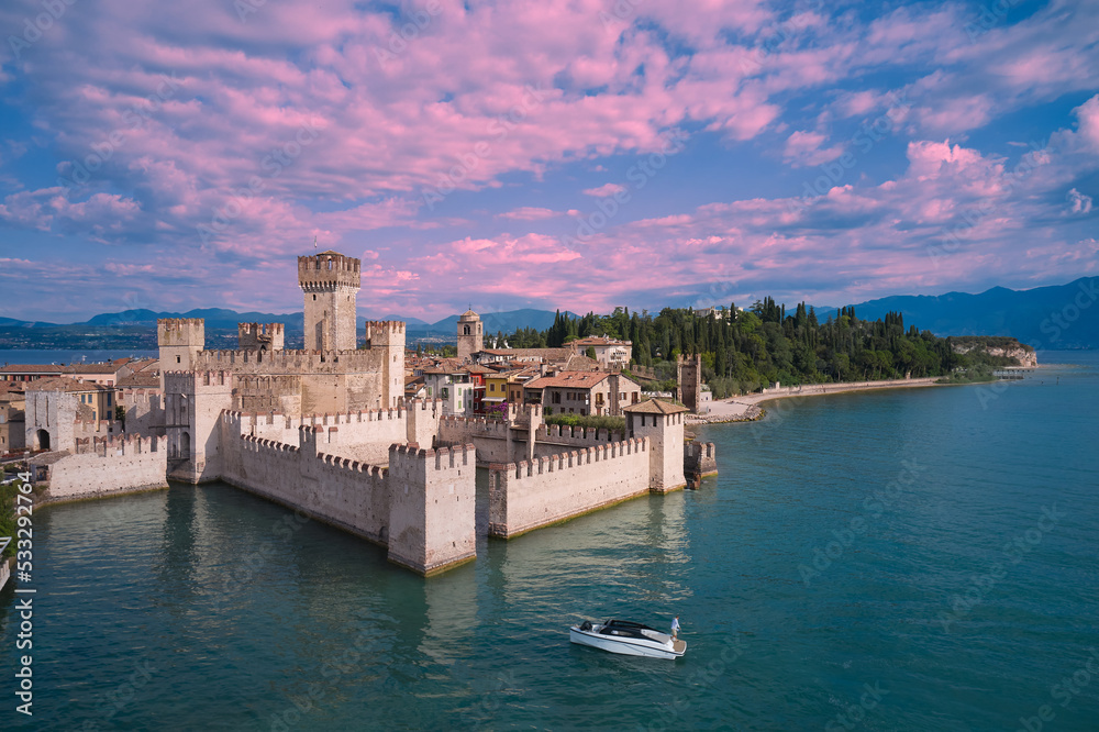 Pink clouds over Scaligero Castle aerial view. Scaligero Castle at sunrise, Lake Garda, Italy. Scaligero Castle aerial view.