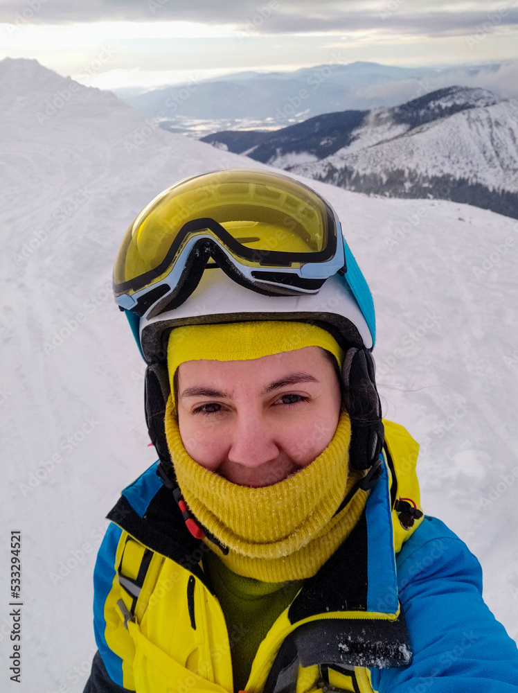 smiling woman taking selfie in ski equipment