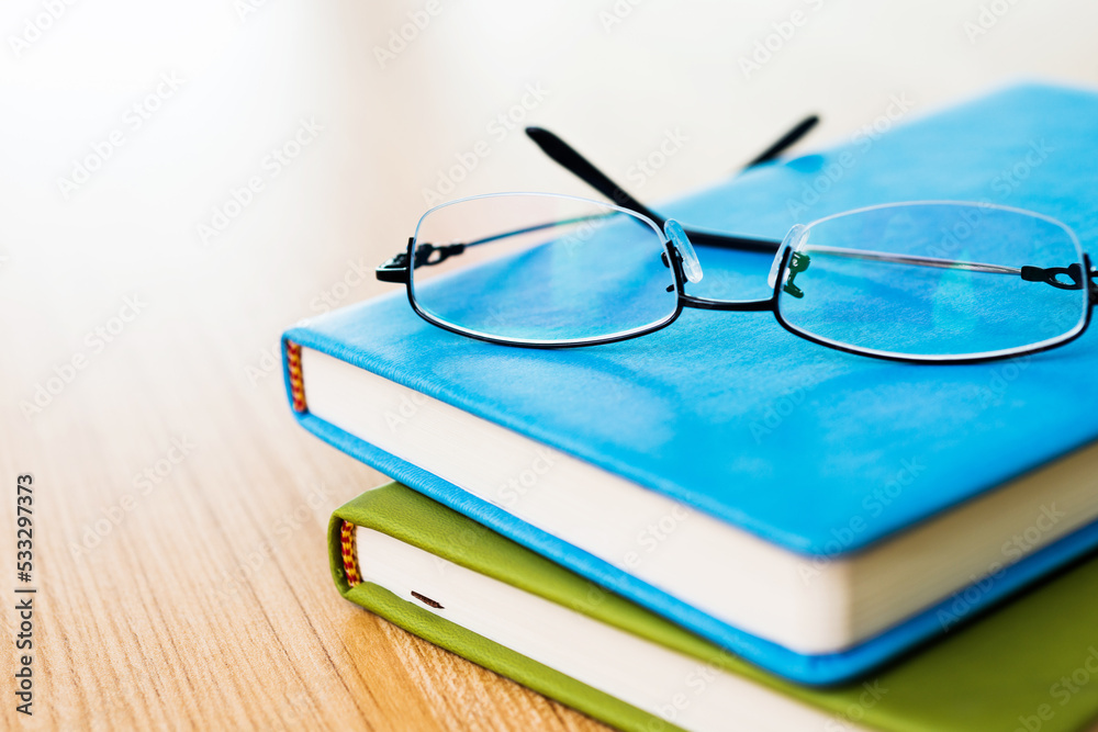 Glasses and books on wooden table Glasses and books on wooden table