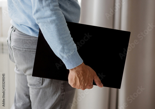 Man holding in hands carrying laptop