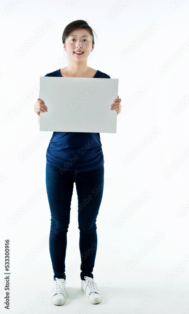Full length young woman holding blank cardboard isolated on white background Full length young woman holding blank cardboard isolated on white background