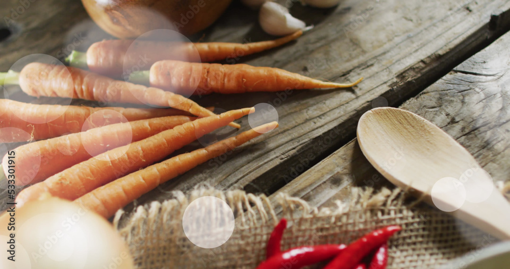 Image of light spots over vegetables and spices on wooden background Image of light spots over vegetables and spices on wooden background