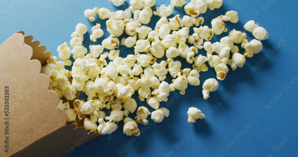 Image of close up of box of popcorn on blue background Image of close up of box of popcorn on blue background
