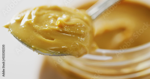 Image of close up of jar of peanut butter on white background