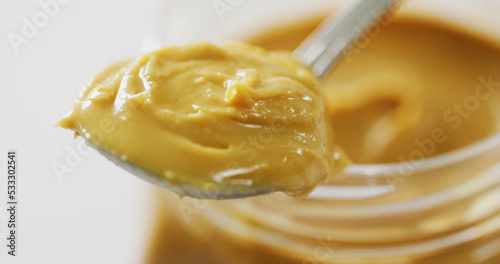 Image of close up of jar of peanut butter on white background