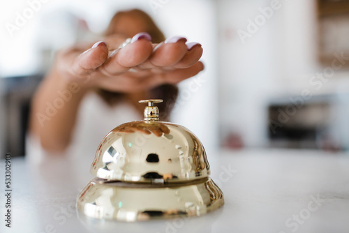 Hand of businesswoman ringing service bell at restaurant photo
