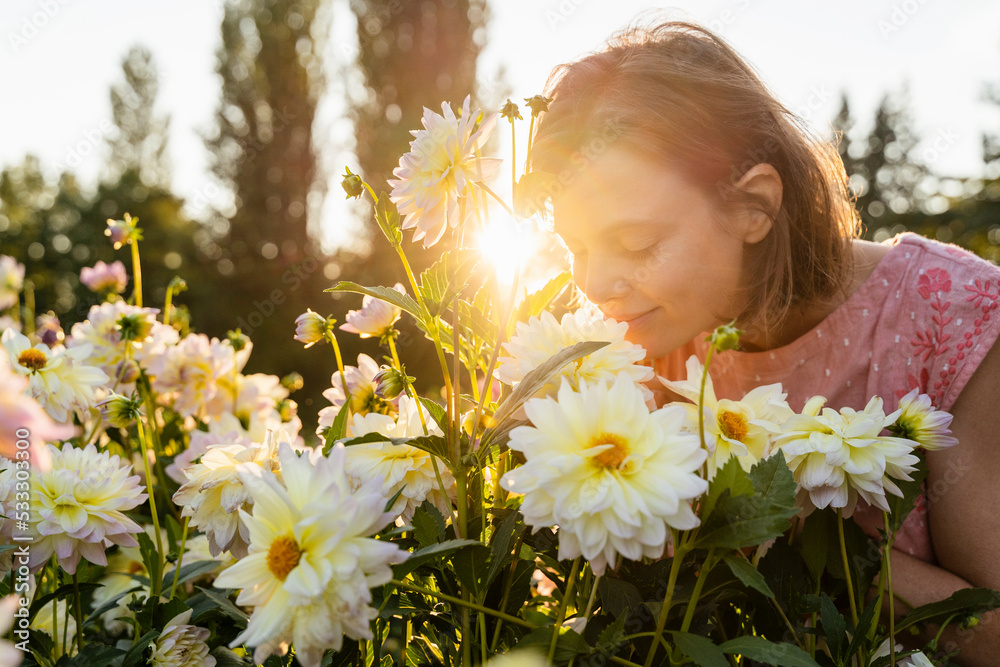 Woman smelling flowers in garden Woman smelling flowers in garden
