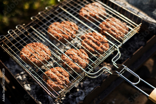 Burger patties in grill at backyard garden photo