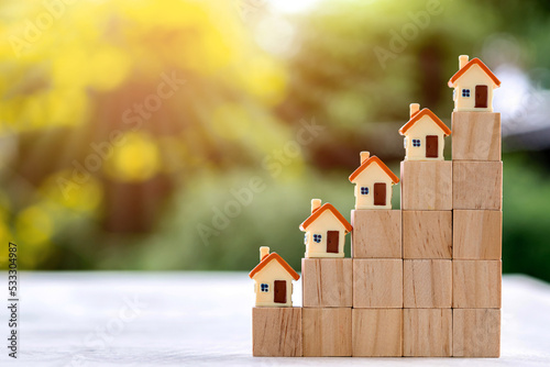 House model placed on top of the growth direction coin. Investing in real estate business for profit or a loan for a home purchase concept.