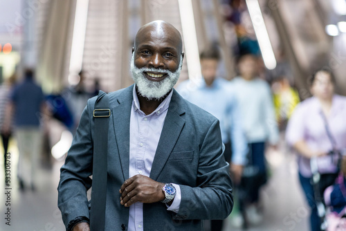 Smiling senior commuter at railroad station photo