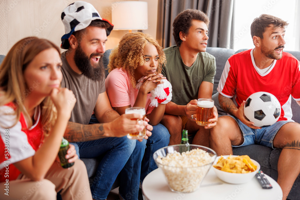 People watching football and cheering at home People watching football and cheering at home