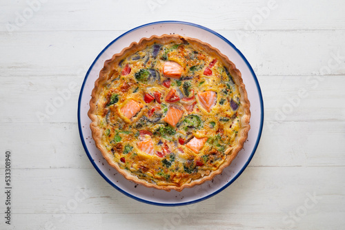 Salmon and vegetable quiche. Traditional French recipe with fish and fresh vegetables with handmade dough and egg.