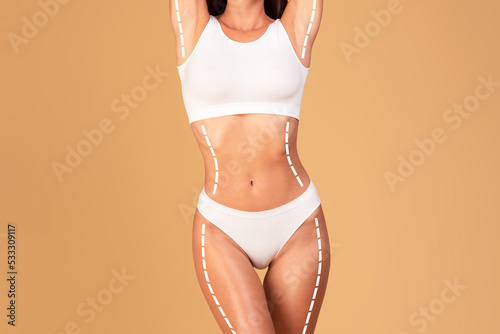 Slimming and tightening concept. Cropped shot of lady in underwear posing with massage lines and arrows on her body
