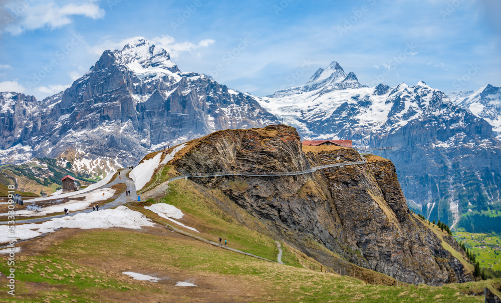 Cliff walk at First peak above Grindelwald village and surrounded snowy Alps, Switzerland.